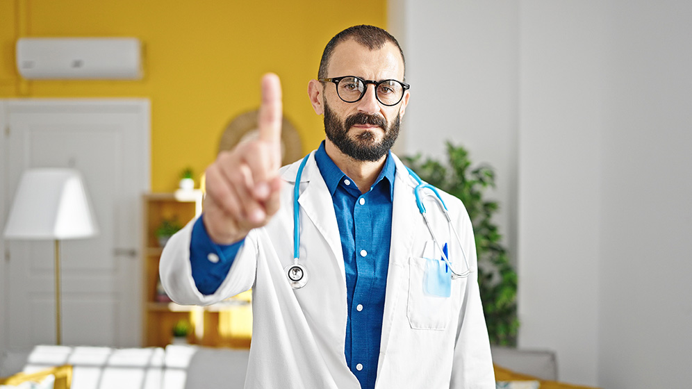 Arzt mit erhobenem Zeigefinger