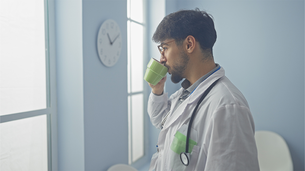 Junger Arzt trinkt eine Tasse Kaffee